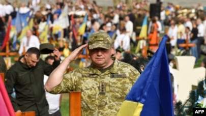 A Ukrainian officer salutes as he attends a ceremony for the fallen soldiers of Ukraine at the Lychakiv Cemetery in the western Ukrainian city of Lviv on Aug. 24, 2022, marking six months since the start of Russia's invasion of Ukraine, and independence D