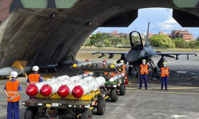 Military personnel stand next to Harpoon A-84, anti-ship missiles and AIM-120 and AIM-9 air-to-air missiles prepared for weapons loading drills in front of an F16V fighter jet at the Hualien Airbase in Taiwan, on Aug. 17, 2022. Taiwan is staging military exercises to show its ability to resist Chinese pressure to accept Beijing's political control over the island. (AP Photo/Johnson Lai)