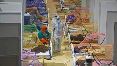Tauseef Mustafa/AFP via Getty Images Health workers wearing personal protective equipment suits attend to COVID-19 coronavirus patients inside a temporary COVID care facility in New Delhi on May 2, 2021.